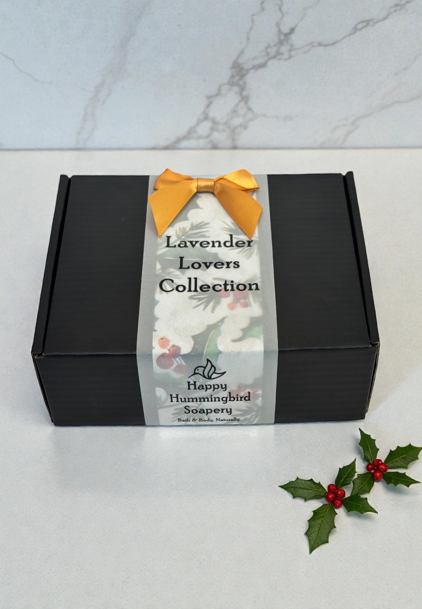 Lavender Lovers Gift Bundle closed black gift box with vellum belly band and gold bow — Happy Hummingbird Soapery.