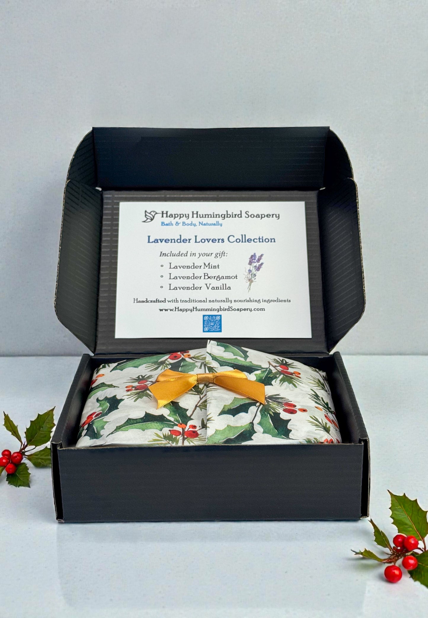 Lavender Lovers Gift Bundle open box with holiday tissue, gold bow, and three lavender cabochon soaps — Happy Hummingbird Soapery.