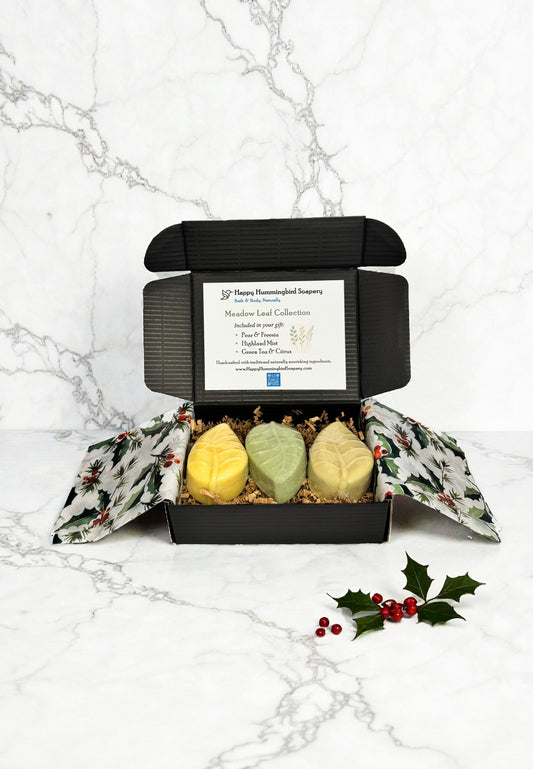 Meadow Leaf Collection open gift box with three leaf soaps, holiday tissue, crinkle fill, and collection card — Happy Hummingbird Soapery.