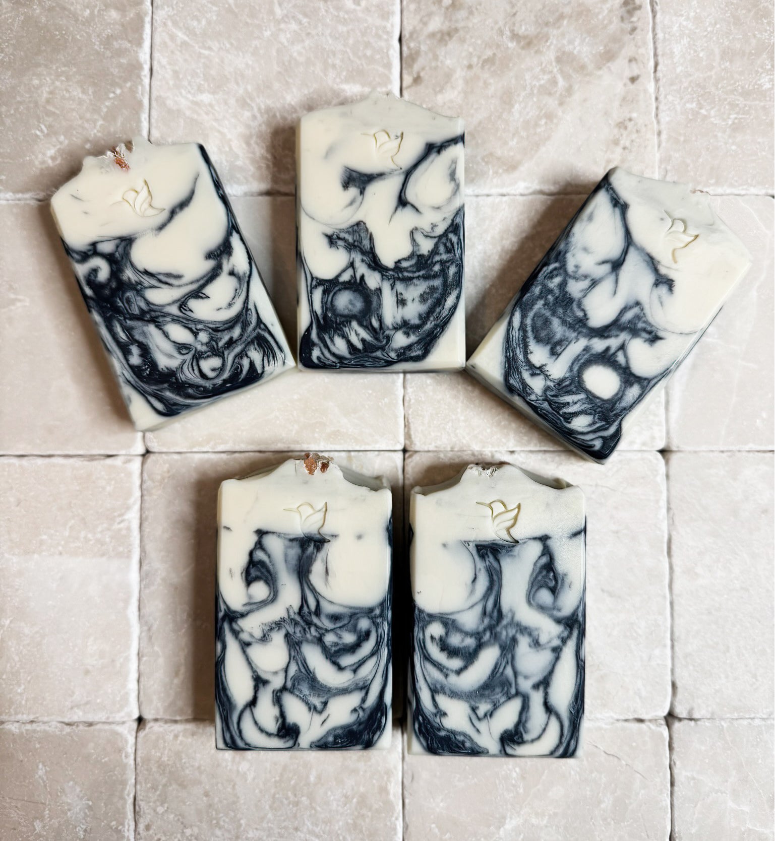 Ocean Drift Charcoal Mineral Soap Bar, by Happy Hummingbird Soapery, group shot of five handcrafted artisan bars featuring a monochrome Breccia marble design arranged on a tiled background.
