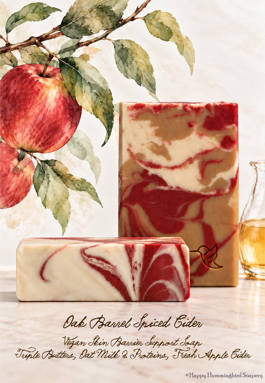 Handcrafted Oak Barrel Spiced Cider cold process soap bars with marbled golden cider, red and cream swirl and a stamped hummingbird logo, displayed on a botanical watercolor background.