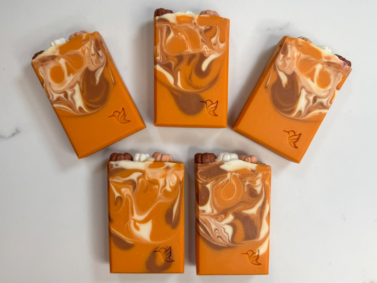 Five hand-cut bars of Pumpkin Chai Latte oat milk soap showing detailed orange, cream, and brown swirls stamped with the Happy Hummingbird logo.